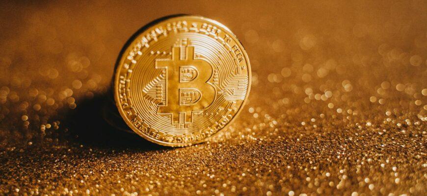 Detailed close-up of a Bitcoin on a glittery gold background, symbolizing digital finance.