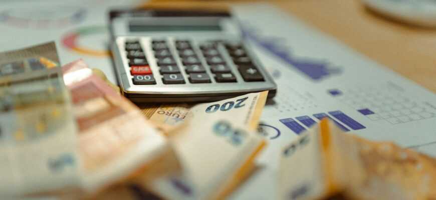 A calculator sitting on top of a pile of money